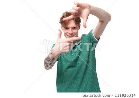 young cheerful red-haired man dressed in a green t-shirt on a background with copy space. lifestyle young cheerful red-haired man dressed in a green t-shirt on a background with copy space. lifestyle 111926314