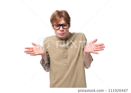 young surprised man with red short hair wearing glasses on a white background with copy space 111926487
