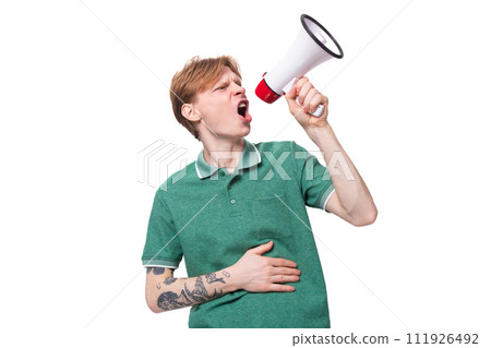 young european man with red hair enthusiastically reports the news through a megaphone 111926492