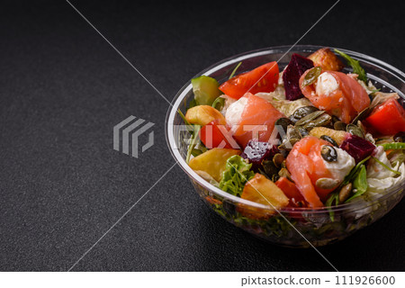 Delicious juicy salad with salmon, tomatoes, cucumber, herbs, pumpkin seeds, salt and spices 111926600