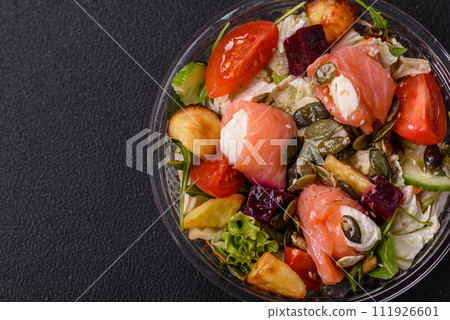 Delicious juicy salad with salmon, tomatoes, cucumber, herbs, pumpkin seeds, salt and spices 111926601