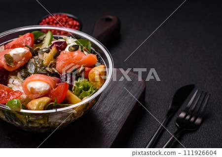 Delicious juicy salad with salmon, tomatoes, cucumber, herbs, pumpkin seeds, salt and spices 111926604