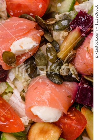 Delicious juicy salad with salmon, tomatoes, cucumber, herbs, pumpkin seeds, salt and spices 111926610