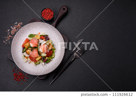 Delicious juicy salad with salmon, tomatoes, cucumber, herbs, pumpkin seeds, salt and spices Delicious juicy salad with salmon, tomatoes, cucumber, herbs, pumpkin seeds, salt and spices 111926612