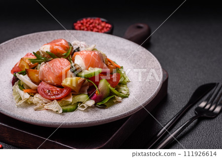 Delicious juicy salad with salmon, tomatoes, cucumber, herbs, pumpkin seeds, salt and spices 111926614