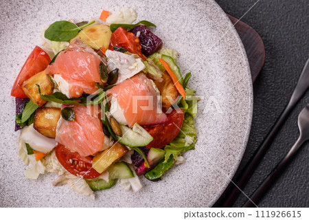 Delicious juicy salad with salmon, tomatoes, cucumber, herbs, pumpkin seeds, salt and spices 111926615