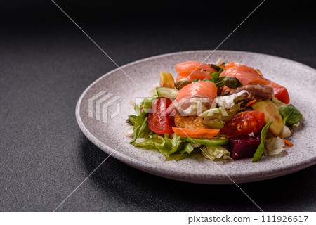 Delicious juicy salad with salmon, tomatoes, cucumber, herbs, pumpkin seeds, salt and spices 111926617