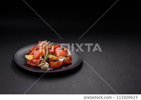 Delicious juicy salad with salmon, tomatoes, cucumber, herbs, pumpkin seeds, salt and spices Delicious juicy salad with salmon, tomatoes, cucumber, herbs, pumpkin seeds, salt and spices 111926623