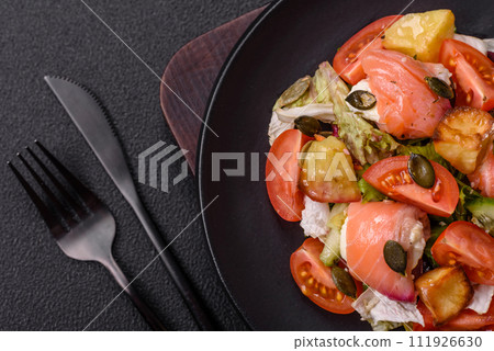 Delicious juicy salad with salmon, tomatoes, cucumber, herbs, pumpkin seeds, salt and spices 111926630
