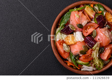 Delicious juicy salad with salmon, tomatoes, cucumber, herbs, pumpkin seeds, salt and spices 111926639