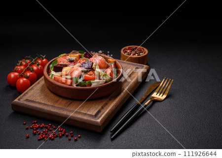 Delicious juicy salad with salmon, tomatoes, cucumber, herbs, pumpkin seeds, salt and spices 111926644