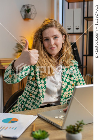 Smiling businesswoman showing thumbs up sign positive something good great news positive feedback 111927015