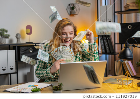 Money cash dollar rain falling on businesswoman with laptop celebrating success win lottery jackpot Money cash dollar rain falling on businesswoman with laptop celebrating success win lottery jackpot 111927019