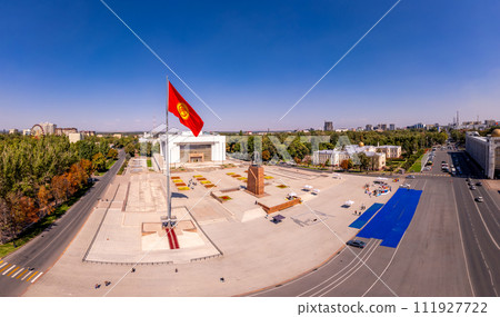 Aerial top view to Flag Kyrgyzstan. Monument Epic Statue of Aykol Manas - kyrgyz hero on Ala-Too Square. State History Museum in downtown of Bishkek city. Central asia, 111927722
