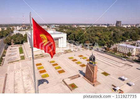 Aerial top view to Flag Kyrgyzstan. Monument Epic Statue of Aykol Manas - kyrgyz hero on Ala-Too Square. State History Museum in downtown of Bishkek city. Central asia, 111927735