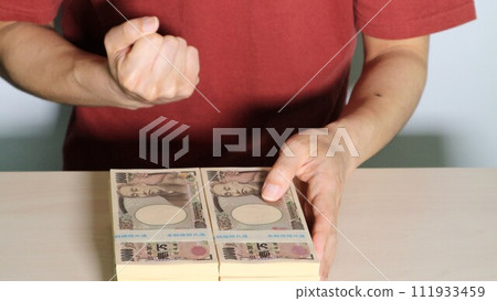 A person with a lot of money and fist pumping 111933459