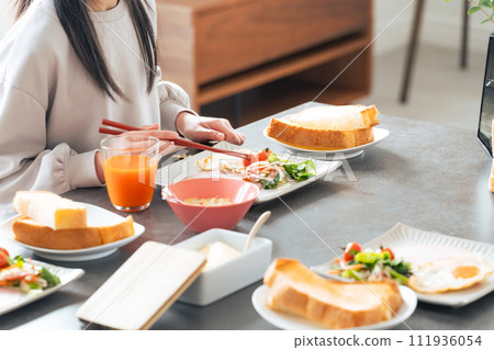 Parent and child eating breakfast in the dining room 111936054