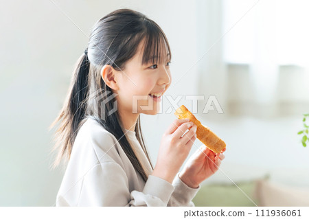Girl eating toast with a smile Girl eating toast with a smile 111936061