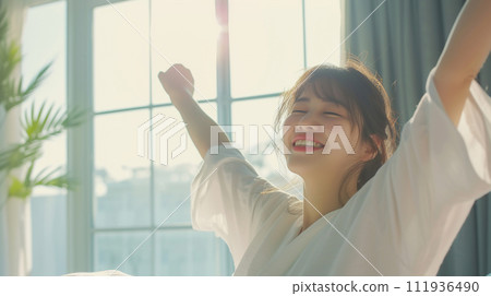 A woman wakes up in the morning and smiles 111936490