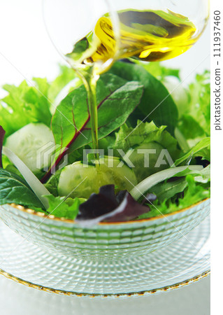 pour olive oil on green salad pour olive oil on green salad 111937460