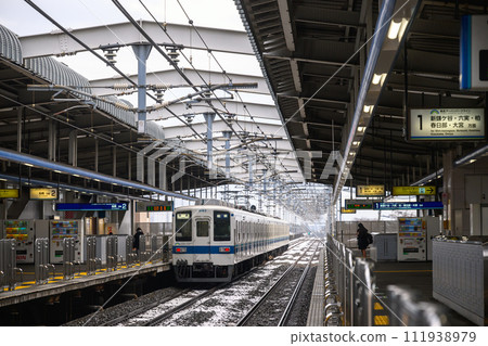 Tobu Urban Park Line Kamagaya Station, a train traveling on an elevated line covered in snow Tobu Urban Park Line Kamagaya Station, a train traveling on an elevated line covered in snow 111938979
