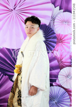 銀色和白色的男士褲裙搭配時尚的長外罩,成年男子穿著鳳紋褲裙,成年儀式外景拍攝 銀色和白色的男士褲裙搭配時尚的長外罩,成年男子穿著鳳紋褲裙,成年儀式外景拍攝 111941548