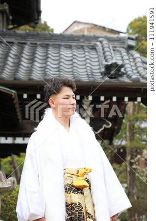 銀色和白色的男士褲裙搭配時尚的長外罩,成年男子穿著鳳紋褲裙,成年儀式外景拍攝 銀色和白色的男士褲裙搭配時尚的長外罩,成年男子穿著鳳紋褲裙,成年儀式外景拍攝 111941591