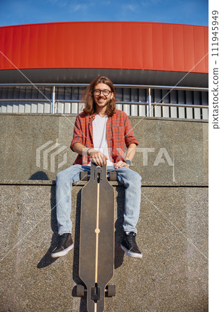 Portrait of stylish smiling hipster male skateboarder enjoying good training 111945949
