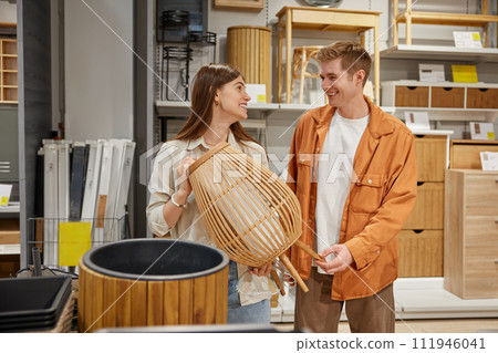 Cheerful man and woman couple deciding to buy craft furniture for home 111946041