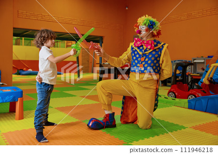 Happy boy and clown playing toy sword made from balloon 111946218