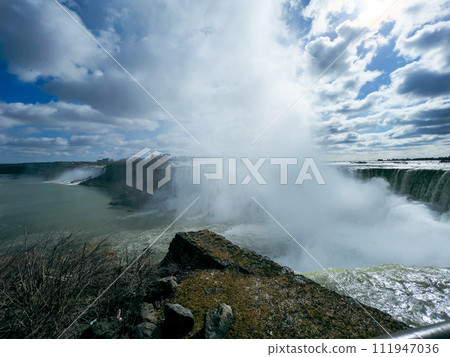 Niagara Falls, Ontario, Canada. Niagara Falls is the largest waterfall in the world. Beautiful view fro the ground near waterfall Niagara Falls, Ontario, Canada. Niagara Falls is the largest waterfall in the world. Beautiful view fro the ground near waterfall 111947036