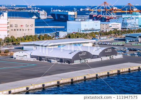 Yokohama cityscape in Japan View of Daikoku Pier passenger ship terminal and car carrier (back) (Aqua Line on the sea) Yokohama cityscape in Japan View of Daikoku Pier passenger ship terminal and car carrier (back) (Aqua Line on the sea) 111947575