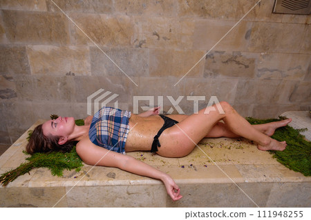 Girl in bikini relaxes after massage in hammam 111948255