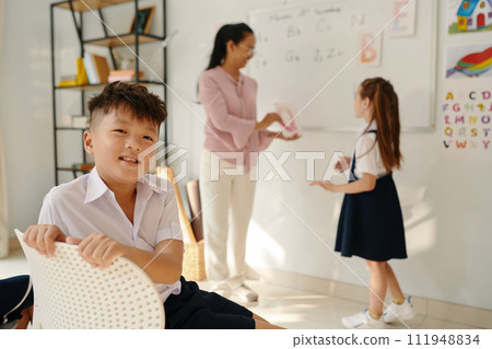 Portrait of happy boy enjoying spending day in class learning English Portrait of happy boy enjoying spending day in class learning English 111948834