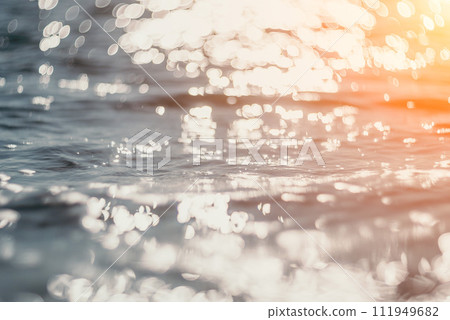 Abstract sea summer ocean sunset nature background. Small waves on golden water surface in motion blur with golden bokeh lights from sun. Holiday, vacation and recreational concept. 111949682
