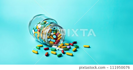 Multi-colored pills in a jar lie scattered on the table on a light blue background 111950076