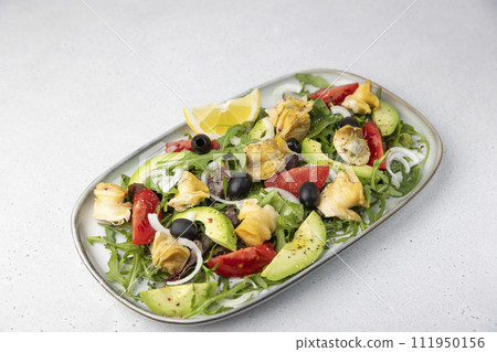 Warm salad with rapans (snails), tomatoes, avocado, arugula, black olives, onions and olive oil. Traditional seafood salad. Close-up, selective focus. Warm salad with rapans (snails), tomatoes, avocado, arugula, black olives, onions and olive oil. Traditional seafood salad. Close-up, selective focus. 111950156