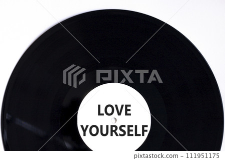 Love yourself symbol. Concept words Love yourself on beautiful black vinyl disk. Beautiful white table white background. Psychology love yourself concept. Copy space. 111951175