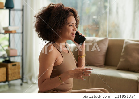 Excited woman calling friend after morning workout 111951354