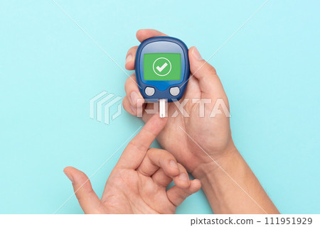 Man using glucometer, checking blood sugar level Man using glucometer, checking blood sugar level 111951929