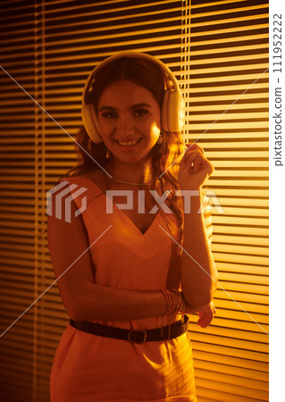 Portrait of smiling Indian girl in headphones enjoying good music 111952222