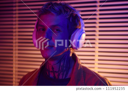 Portrait of young man enjoying listening to song in headphones 111952235