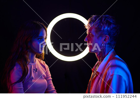Young man and woman looking at each other in night club, love from the fist sight Young man and woman looking at each other in night club, love from the fist sight 111952244