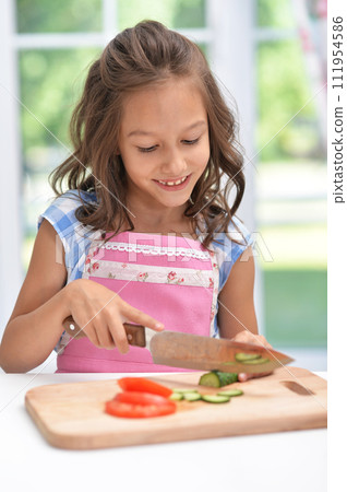 Portrait of cute little girl making dinner 111954586