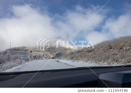 View from a car driving on a snowy road View from a car driving on a snowy road 111954596