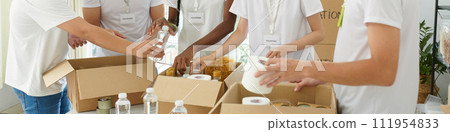 Banner with volunteers of charity organization packing food for people in need 111954833