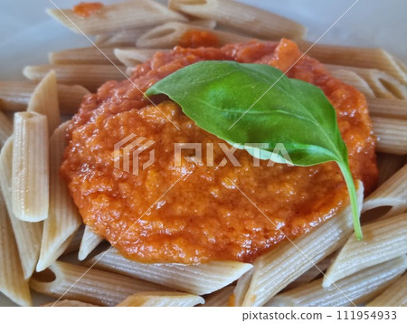 Whole wheat penne pasta with fresh basil and tomato sauce 111954933
