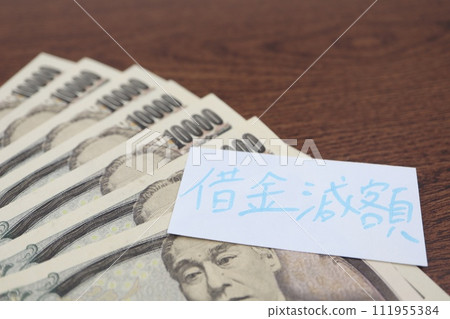 A paper with debt reduction written on it and a 10,000 yen bill 111955384