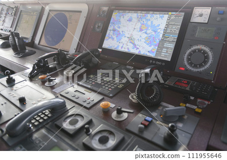 Navigational control panel and VHF radio. Working on the ship's navigational bridge. Blurred image. Navigational control panel and VHF radio. Working on the ship's navigational bridge. Blurred image. 111955646