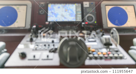 Navigational control panel and VHF radio. Working on the ship's navigational bridge. Blurred image. Navigational control panel and VHF radio. Working on the ship's navigational bridge. Blurred image. 111955647